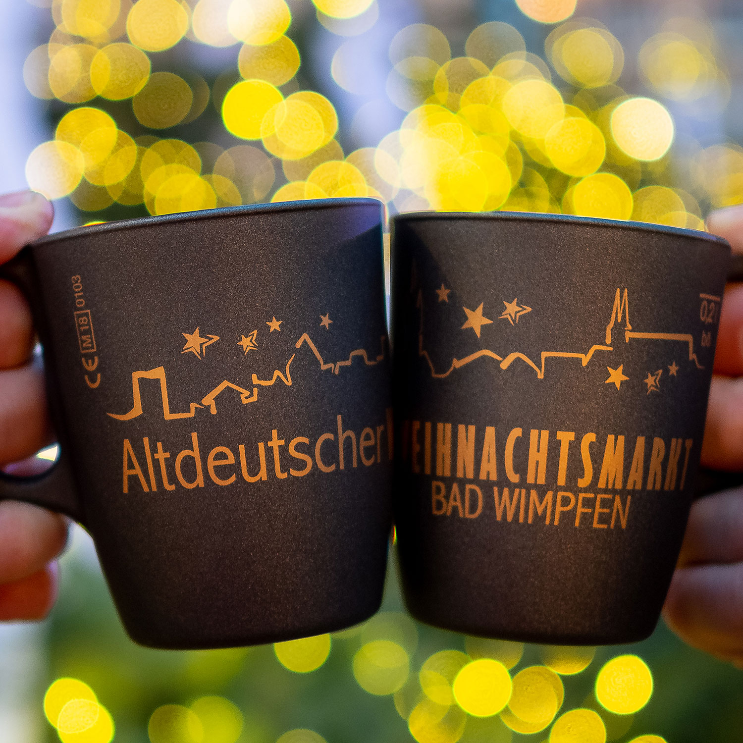 Weihnachtsmarkt-Bad-Wimpfen_Tassen_200_quadr 2 Glühweintassen werden nebeneinander gehalten